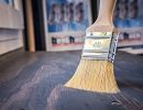 Pinsel liegt auf lasierter Holzfl&auml;che, Farbauftrag im Detail, Hinweis auf Holzschutz und Gestaltung mit Lasur